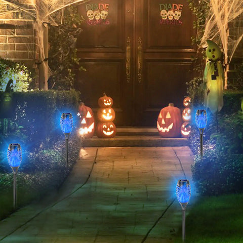 Blue Solar Torch Lights With Flickering Flames, 12 Pack Outdoor LED Tiki Torches illuminating garden pathway at night