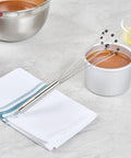 Stainless Steel Ball Whisk With Silicone Tips 10.5 Inch 24 Pack Non Scratch Dishwasher Safe next to baking items on counter