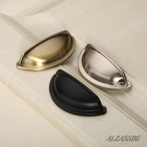 Premium Upgraded Top Shelf 3 Inch Brushed Antique Brass Cabinet Cup Pulls in three finishes on cabinet surface.