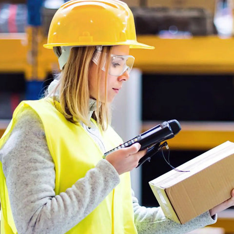 Woman wearing Six Pair Safety Glasses With Ventilated Louvered Frames And Wraparound Side Shields for lab work, holding a package.