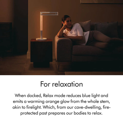 Modern room with Solarcycle Morph Desk Light With Adaptive Daylight Tracking next to person relaxing on couch