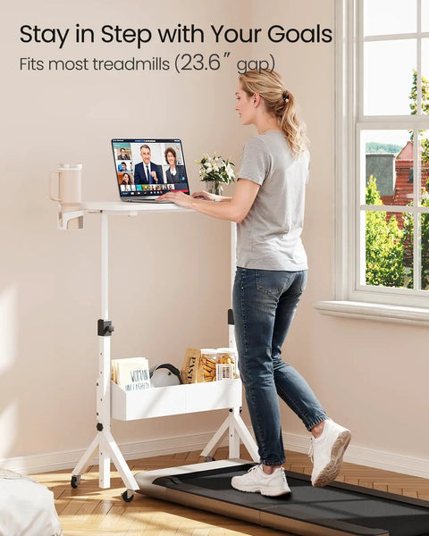 Woman using Mobile Standing Desk With Wheels, Height Adjustable, on treadmill, with cup holder and laptop in bright room.