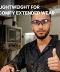 Kickass Anti Fog Safety Glasses Featuring Scratch Proof Optical Shielding Durable Polycarbonate Lenses And Ansi Z87 Impact Resistance For Heavy Duty Work Site Operations worn by a worker giving a thumbs up in a workshop.
