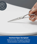 Scissors on Starck 3 Toilet Seat White High Gloss With Soft Close Lid And Stainless Steel Hinges Tool Free Removal For Quick Cleaning Durable Duroplast Construction Antistatic Water Resistant UV Resistant, demonstrating durability.