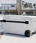 MaxCold Glide 110 Qt Insulated Rolling Cooler With Soft Ride Wheels 168 Can Capacity shown dockside with handle extended