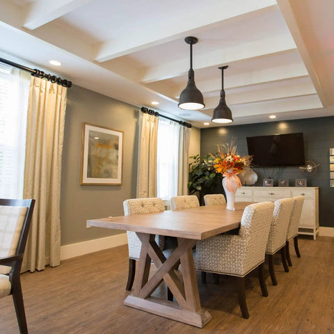 Modern dining room with hanging lights and long wooden table, showcasing interior lighting suitable for A19 Led Light Bulbs 9W, 60W Equivalent, E26 Base, Daylight White 5000K, Dimmable, Energy Efficient, 10,000 Hour Lifespan, 6 Pack For Home Office Lighting.
