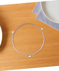 Microwave Turntable Support Roller Ring And Glass Plate Adapter on wooden surface with plate and napkin.