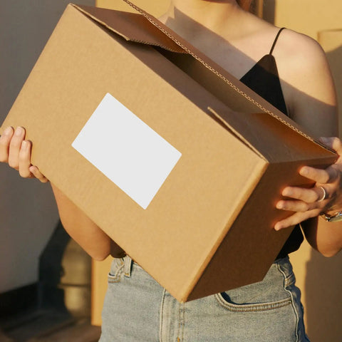Person holding a box with Strong Adhesion Sticker Labels Set With 160 White Synthetic Paper Sheets for shipping