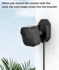 Three Pack No Drill No Screws Adhesive Wall Mount Brackets with Blink camera mounted and cord in bracket outdoors.