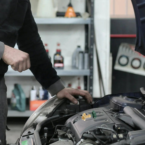 Mechanic using a Heavy Duty Car Ac Refrigerant Tank Adapter For Freon Refill Charging Valve Kit on car engine.