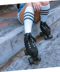 Skater resting wearing quad roller skates with Adjustable Elastic Brake Block For Quad Roller Skates And Ice Skates Rubber Brake Stopper Kit