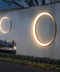 Massive 80cm Outdoor Wall Light Brushed Stainless Steel Round LED Sconce on a wall, illuminating garden details beautifully.