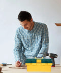Rock Solid Portable Plastic Toolbox Organizer With Smart Compartments For Easy Carry And Outdoor Use on a work table with a man.