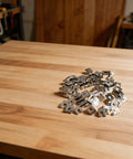 100 Pack Solar Grounding Clips 304 Stainless Steel Conductive Washer Kit in a pile on wooden table surface.