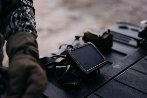 Kickass Rugged Solar Power Panel With Hella Durable Weather Resistant Housing and Fast Charge USB Port on a dark surface.