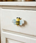 Hella Cute Yellow Honey Bee Ceramic Drawer Knobs And Cabinet Pulls attached to a white drawer front, adds charm to kids furniture.