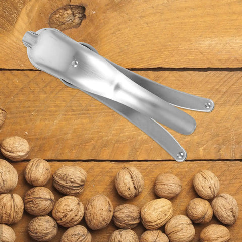 Heavy Duty Stainless Steel Nut Cracker And Walnut Opener For Almonds Shells Crack Chestnuts With Ease Ergonomic Handle on wooden table with walnuts.