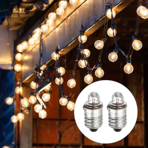 Genuine Top Shelf Slick Four Pack E10 Miniature Screw Base Light Bulbs 3 Volt 0.3 Amp Warm Yellow Glow Lamps for Electronics Tinker Project Gear displayed with soft glowing string lights.