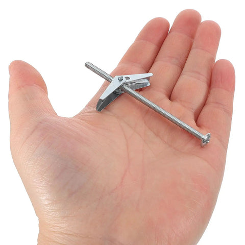 Hand holding a heavy duty toggle bolt from the 24 Piece Toggle Bolts and Wing Nuts Set for Drywall Mounting, Iron Fastener