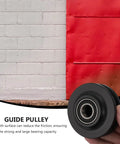 Heavy Duty Nylon Sliding Door Guide Wheel Pulley For Barn Door Track Systems, black pulley in hand with red barn door background.