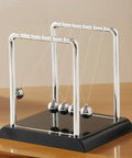 Cradle Balance Pendulum Balls Set With Black Base, Kinetic Fidget Desk Toy, metal balls on nylon hangers, on a wooden desk