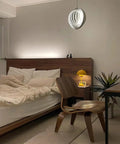 Dope 360 Degree Adjustable Moon Pendant Light With Rotating Sphere Shade in a modern bedroom with wooden furniture