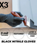 Person wearing Black Nitrile Disposable Gloves 3 Mil Powder Free Large for cooking and food prep, painting a wooden surface