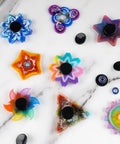 Colorful fidget spinner designs with black end caps and chrome steel bearings, featuring various shapes and colors.