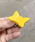 Hella Chic Yellow Ceramic Butterfly Cabinet Knobs Premium Six Piece Set shown in hand, close-up view, durable and vintage design.