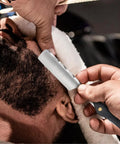 Premium Straight Razor And Leather Shaving Strop Set With Sharp Stainless Steel Blade And Smooth Wooden Handle For Men being used on a man's beard during a grooming session.