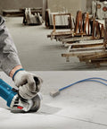 Hardcore Soft Start Module For Angle Grinder 15A 250V beside angle grinder on work surface, shows installation use and workspace.