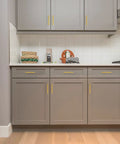 Killer Gold Cabinet Pulls Slim Kitchen Handles With Butter Smooth Fitting Dead On 5 Inch Center To Center Spacing For Easy Cupboard Refresh Top Tier Home Hardware Thirty Piece Set installed on modern gray kitchen cabinets.