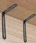 Four Pack Rock Solid Stainless Steel L Shaped Corner Brackets Featuring Dual Adjustable Slide Slots For No Sweat Setup And Heavy Duty Shelf Support Hardware In Smooth Matte Black Finish displayed on wood.