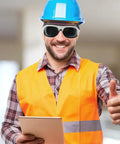 Smiling worker in safety gear wearing Kickass Protective Eyewear And Safety Glasses With Lenses For Welders, bright orange vest, blue helmet.
