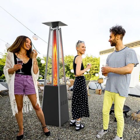 Group of people around a tall four-sided outdoor liquid propane patio heater with visible replacement glass tube