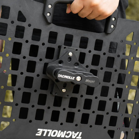 Person holding a Universal MOLLE Mounting Bracket Base on a panel, showing the bolt-on design for accessories