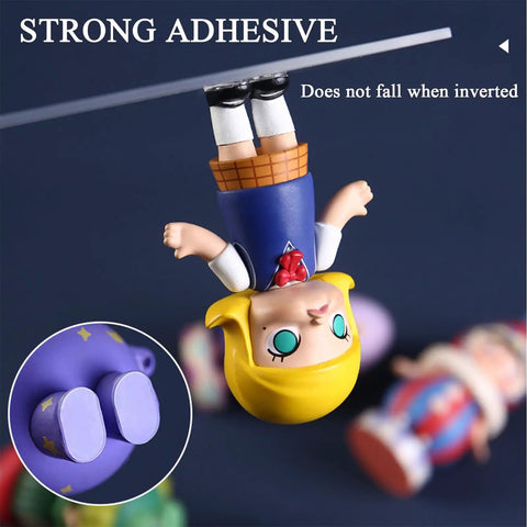 Image showing two-sided mounting putty dots holding a toy upside down, highlighting strong grip. Two Sided Mounting Putty Dots For Wall Hanging Crafts And Party Decor, Clean Removable Poster Tack For Balloons And Festivals, Residue Free Adhesive Dots That Stick Like Crazy, Easy To Use And Leaves No Mess.