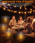 People dining outdoors with Twin Pack Outdoor Bluetooth Flame Speaker With LED Torch Dope Ambience Light, creating a cozy atmosphere.