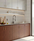 Modern kitchen with champagne bronze cabinet pulls, stainless steel sink, and wooden cabinetry, featuring a sleek design.
