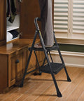 Heavy Duty 2 Step Folding Ladder With 500 Lb Capacity Anti Slip Wide Pedals Beefy Steel Frame used in home for reaching cabinet