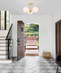 Gold 3 Light Semi Flush Mount Ceiling Light Fixture With Off White Hand Blown Glass Shade illuminating a modern hallway.