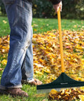 Man using 55 Inch Turf Rake With Dense Nylon Bristles All In One Long Pole Garden Hand Broom for leaf cleanup on lawn