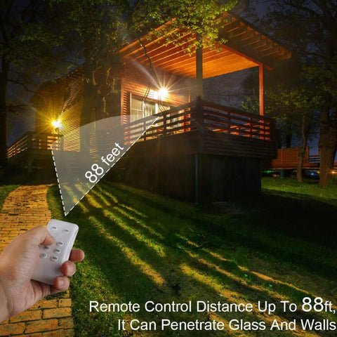 JUDYSSY Solar Flood Lights Led Solar Light showing remote control range of 88 feet with illuminated cabin in background.