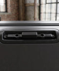 Solid Luggage Handle Button Replacement For Suitcases Black Plastic Pull Grip Straight Up Repair Part showing close-up view on suitcase handle.