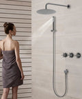 Shower System Wall Mounted 10 Inch Stainless Steel Rain Shower with a woman standing under the rain shower in a modern bathroom.