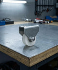 Heavy Duty Double Hole Bracket Pulley With Nylon Wheel Track Roller And Sealed Bearing Axle on metal workbench.