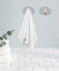 Six Pack Peel And Stick Wall Hooks With Rock Solid Hold For Zero Hassle Bathroom Setup Self Adhesive Hangers For Towels Hats Coats And Everyday Carry holding a white towel.
