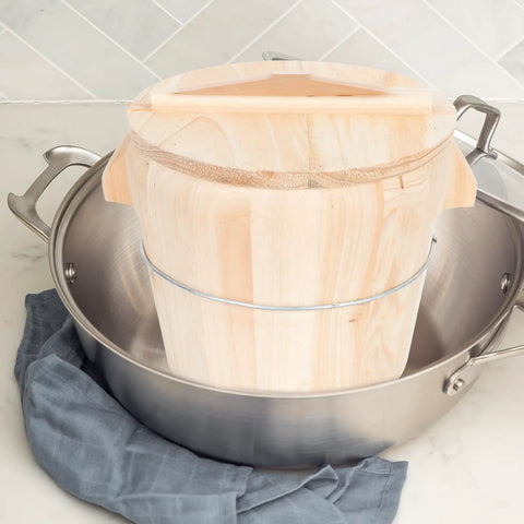 Top Shelf Wooden Rice Steamer Bucket With Smooth Detachable Bottom And Secure Lid For Zero Sweat Kitchen Cleanup placed in stainless steel pot.