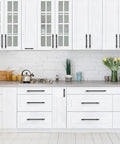 Matte Black 25 Pack Cabinet Handles 3 Inch Hole Centers 5 Inch Overall Length installed on white kitchen cabinets