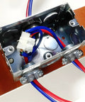 Rock Solid 12 Piece One Half Inch Clamp Cable Connectors No Sweat Zinc Alloy Quick Install Zero Drama Heavy Duty Electrical Wire Joiners installed in metal electrical box with red and blue wires.